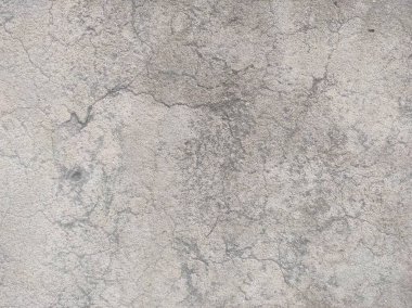 Kirli çatlamış beyaz duvar boyası soyuluyor. Ağır hasarlı eski duvar boyası soyuluyor. Boya parçaları kayıp. Yıpranmış grunge duvar dokusundan çimento sıyrılmış..