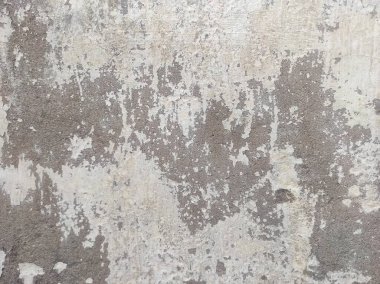 Kirli çatlamış beyaz duvar boyası soyuluyor. Ağır hasarlı eski duvar boyası soyuluyor. Boya parçaları kayıp. Yıpranmış grunge duvar dokusundan çimento sıyrılmış..