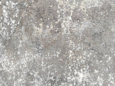 Kirli çatlamış beyaz duvar boyası soyuluyor. Ağır hasarlı eski duvar boyası soyuluyor. Boya parçaları kayıp. Yıpranmış grunge duvar dokusundan çimento sıyrılmış..