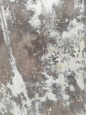 Kirli çatlamış beyaz duvar boyası soyuluyor. Ağır hasarlı eski duvar boyası soyuluyor. Boya parçaları kayıp. Yıpranmış grunge duvar dokusundan çimento sıyrılmış..