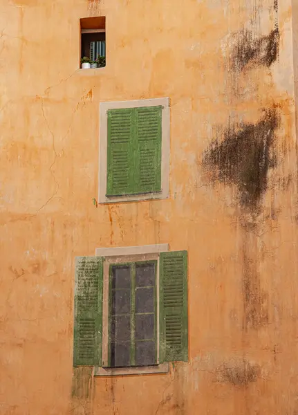 Duvarında yeşil panjurlar olan pencere.