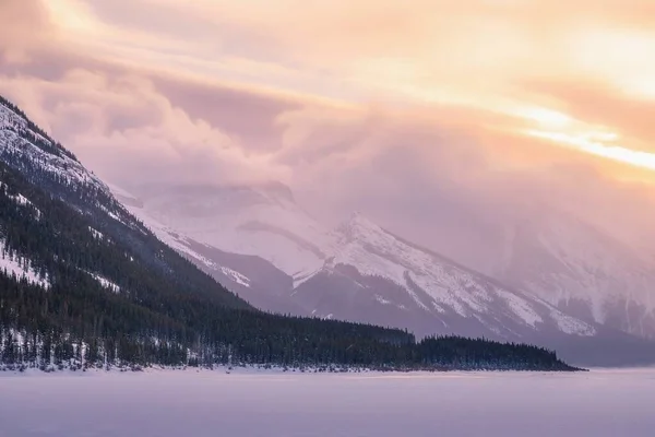 雪に覆われた山の上に昇る日の出雲 — ストック写真