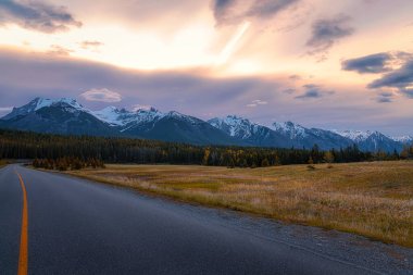 Banff 'ta bir dağ yolunda parlayan gün doğumu gökyüzü