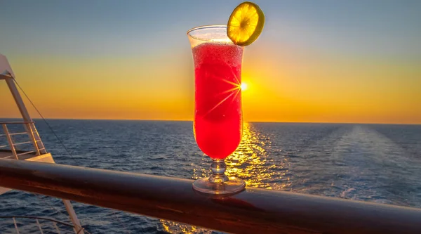 View of a cocktail party on the deck of a cruise ship at sunset in the wake of the cruise ship. View from the stern of the ship.