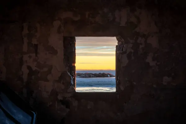 漁小屋の窓からカマルグの池の夕日を見る 保護された自然保護区 ストック画像