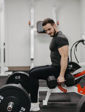 Young man trains his body to stay fit and have defined muscles.