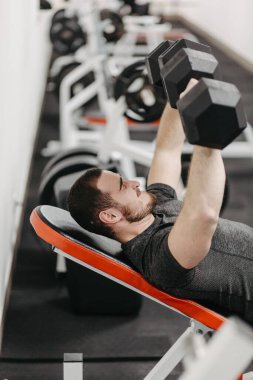 Young man trains his body to stay fit and have defined muscles.
