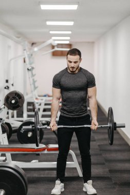 Young man trains his body to stay fit and have defined muscles.