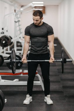 Young man trains his body to stay fit and have defined muscles.