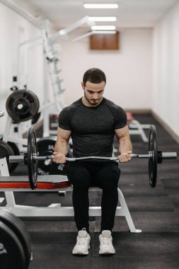 Young man trains his body to stay fit and have defined muscles.
