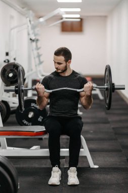 Young man trains his body to stay fit and have defined muscles.
