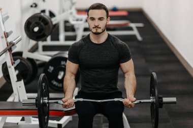 Young man trains his body to stay fit and have defined muscles.