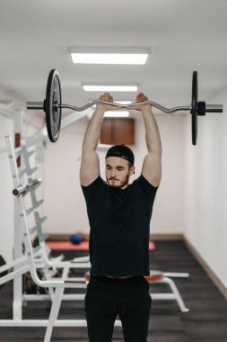 Young man trains his body to stay fit and have defined muscles.