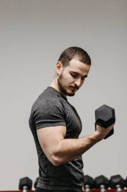 Young man trains his body to stay fit and have defined muscles.
