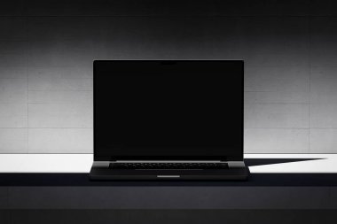 Beton zemin üzerinde boş ekranı olan açık bir dizüstü bilgisayarı olan bir sahne