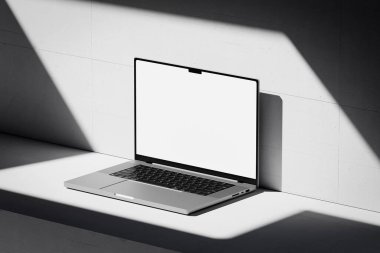 Beton bir arka planda boş beyaz ekranlı açık bir dizüstü bilgisayarı olan bir sahne