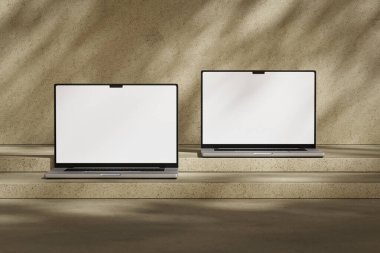 Boş beyaz ekranlı iki açık dizüstü bilgisayar