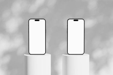 Podyumda boş beyaz ekranlı iki cep telefonlu sahne