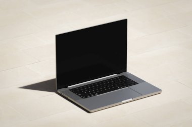 Hafif tuğla podyumda boş bir ekranla açılan dizüstü bilgisayar