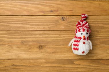 Ahşap arka planda küçük bir Noel kardan adam, üst manzara.