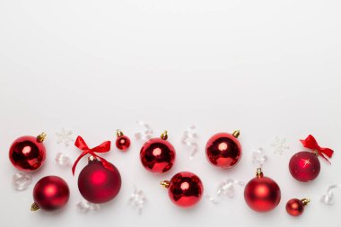 Beyaz arka planda Noel oyuncakları ve konfeti, üst manzara.