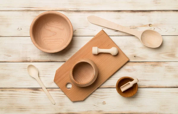 stock image Wooden cutlery, bowls and board on wooden background, top view.