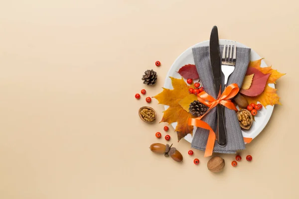 カトラリー ナプキン 色の背景に秋の装飾が施されたプレート トップビュー 感謝祭テーブルの設定 — ストック写真