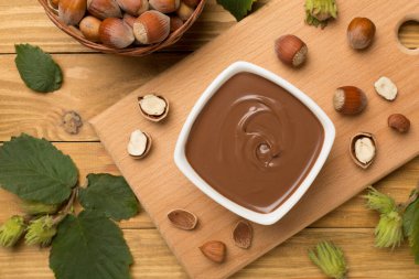 Fındık kremalı ve ahşap arka planda yeşil yapraklı..