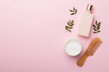 Bitkisel özlü şampuan ve saç kremi ve renk arkaplan tarağı, üst görünüm.
