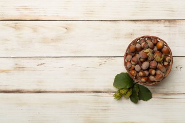 Ahşap arka planda yeşil yapraklı fındıklar..