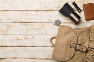 Travel accessories for mountain trip on wooden background, top view.