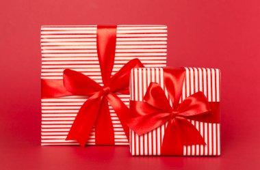 Arkaplanda kırmızı kurdele olan hediye kutuları.