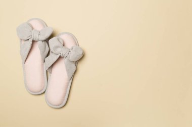 Soft pink slippers on color background, top view.