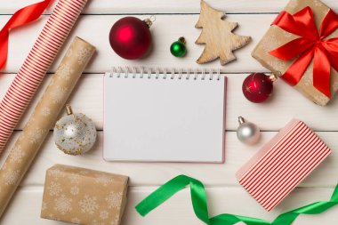 Gift boxes, paper's rools and decorations on wooden background, top view.
