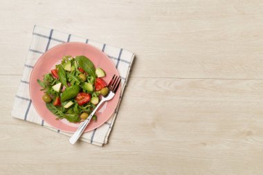 Tahta arka planda roka, ıspanak ve sebzeli taze salata..