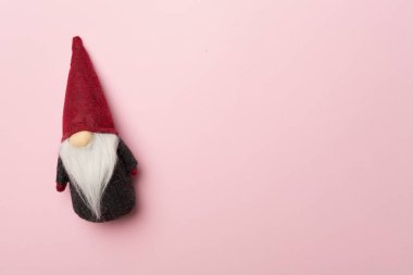 Renkli arka planda küçük bir Noel cücesi, üst görünüm.