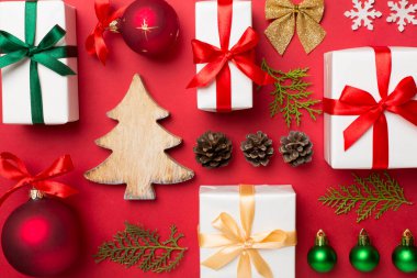 Renkli arka planda noel hediyeleri, oyuncaklar, ardıç ve koniler vardı..