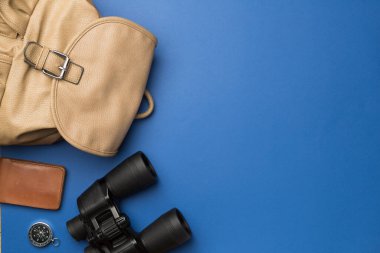 Travel accessories for mountain trip on color background, top view.