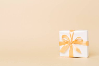 Arkaplanda altın kurdeleli hediye kutusu.