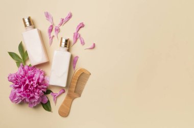 Şakayık çiçekli şampuan ve saç kremi ve renk arkaplan tarağı, üst görünüm.