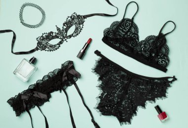 Renk arkaplanında aksesuarları olan siyah seksi dantel iç çamaşırı seti..