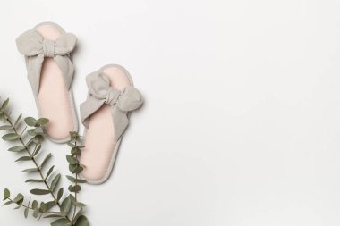 Soft pink slippers on color background, top view.