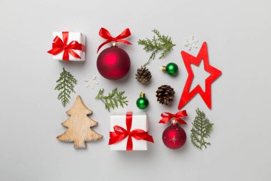 Renkli arka planda noel hediyeleri, oyuncaklar, ardıç ve koniler vardı..