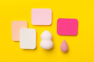 Beauty blenders on color background, top view