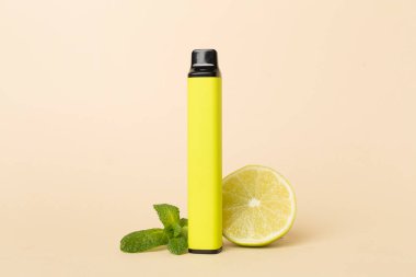 Disposable electronic cigarette and fruit on color background