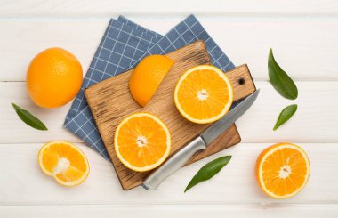 Flat lay with fresh oranges and leaves on wooden background