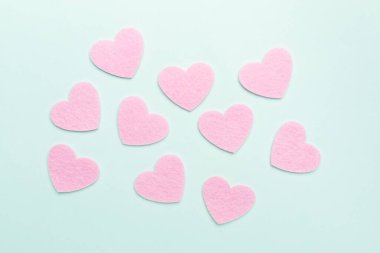 Felt hearts on color background, top view