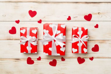 Gift boxes with hearts on wooden background, top view