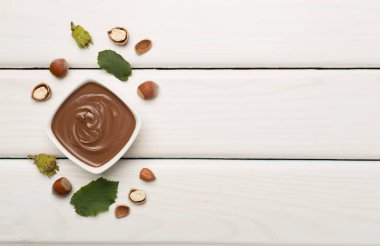 Fındık kremalı ve ahşap arka planda yeşil yapraklı..