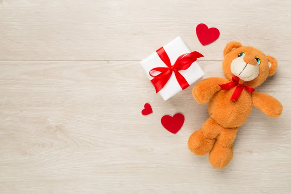 Gift boxes with soft toy on wooden background, top view